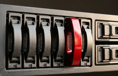 Nahaufnahme von Server-Laufwerksschächten aus Graphit, ein Griff rot – Serverbetreuung und Wartung